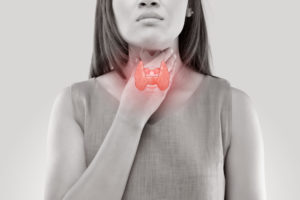 Woman touching her throat with a visual overlay of a thyroid gland, indicating a possible thyroid or parathyroid issue.