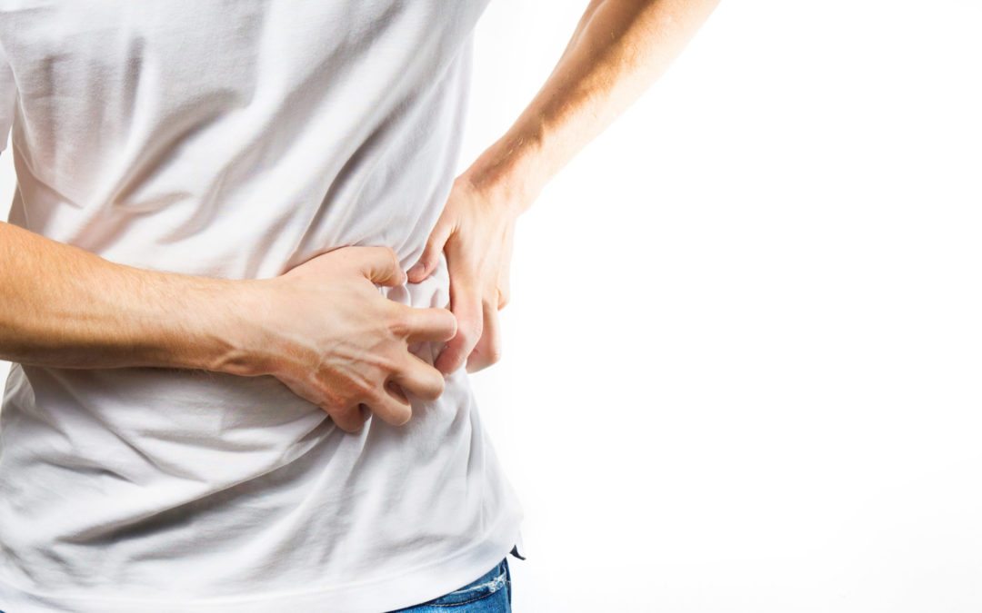 Person clutching their lower back in pain on a white background.