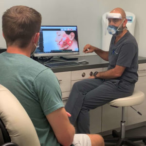 Doctor discussing medical images with a patient in a consultation room.